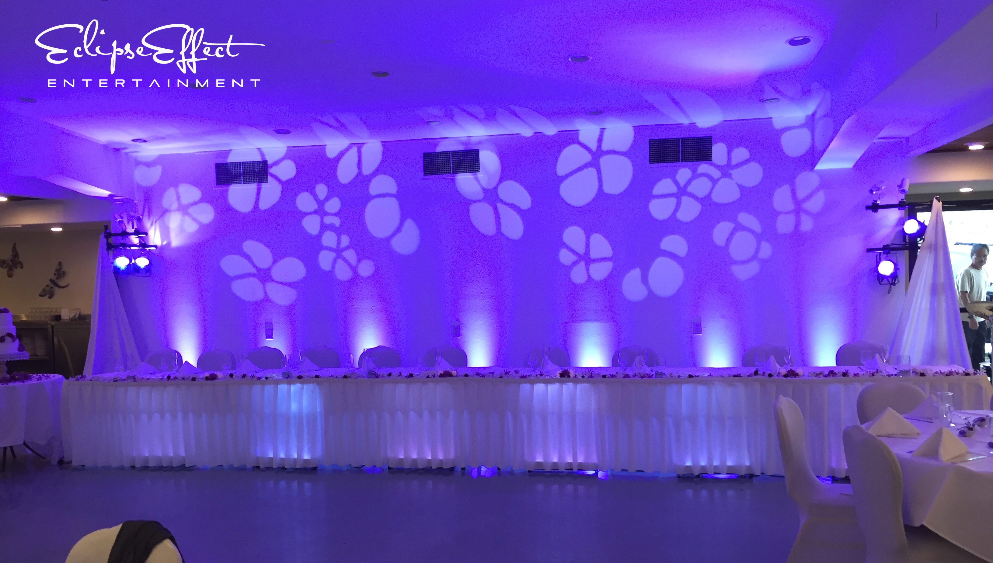 Head table uplighting in purple with cherry blossom design.
